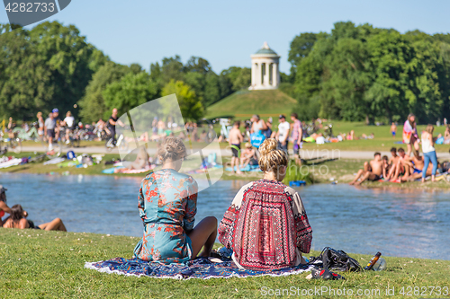 Image of People tanning, swimming and enjoying the summer in Englischer Garten in Munich, Germany.