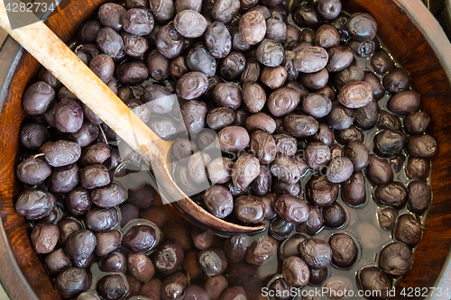 Image of Olives in wooden bowls with serving spoon.