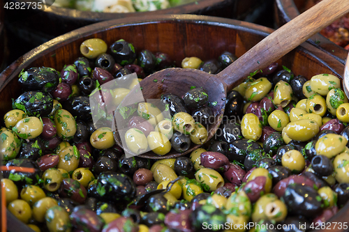 Image of Olives in wooden bowls with serving spoon.