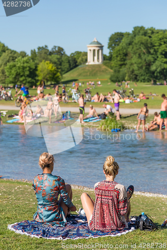 Image of People tanning, swimming and enjoying the summer in Englischer Garten in Munich, Germany.