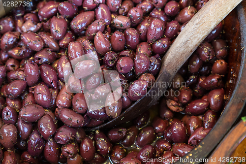 Image of Olives in wooden bowls with serving spoon.