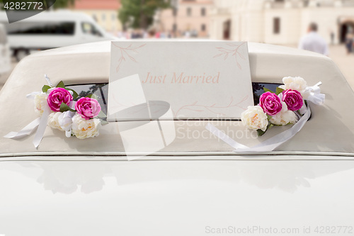 Image of White wedding limousine decorated with flowers