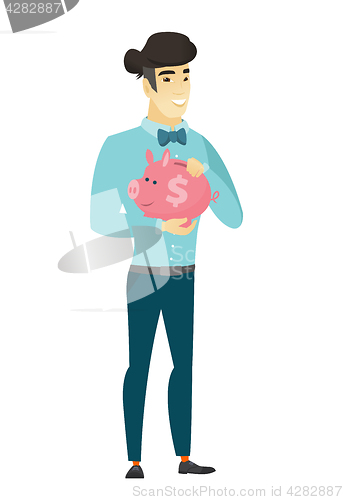 Image of Asian business man holding a piggy bank.