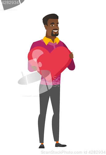 Image of African business man holding a big red heart.
