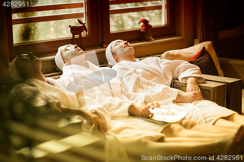 Image of women is getting facial clay mask at spa