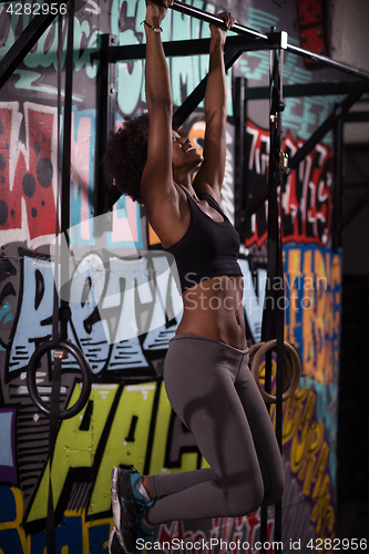 Image of black woman doing pull ups