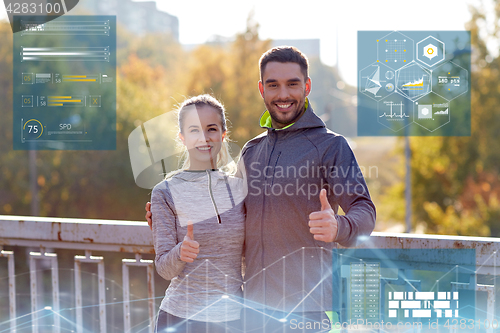 Image of smiling couple showing thumbs up outdoors
