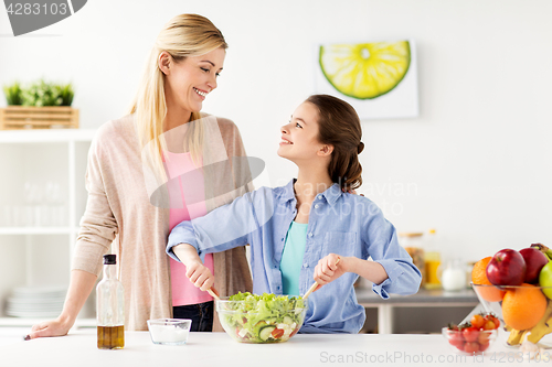 Image of happy family cooking salad at home kitchen