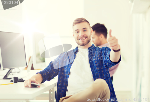 Image of happy creative man with computer at office