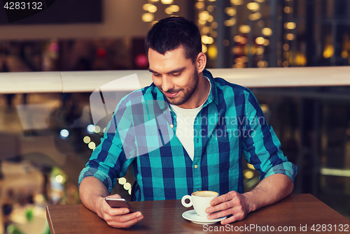 Image of happy man with smartphone and coffee at restaurant