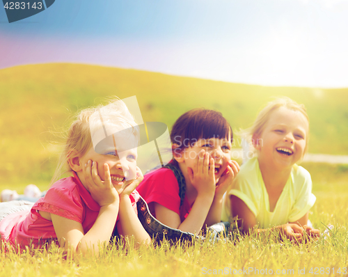 Image of group of kids lying on blanket or cover outdoors