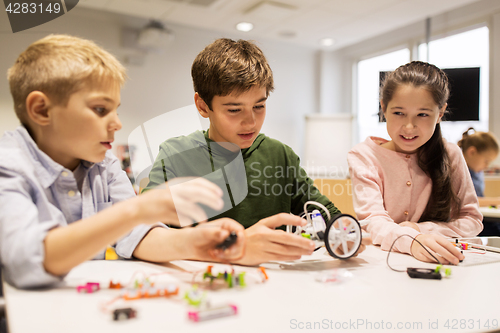 Image of happy children building robots at robotics school