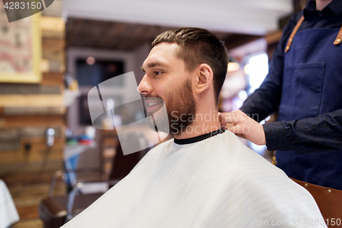 Image of hairdresser and man with beard at barbershop