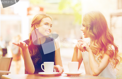 Image of young women drinking coffee and talking at cafe