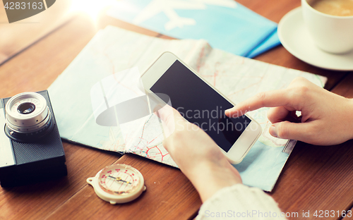 Image of close up of traveler hands with smartphone and map