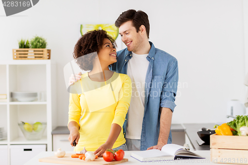 Image of happy couple cooking food at home kitchen