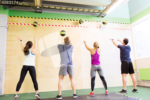 Image of group of people with medicine ball training in gym