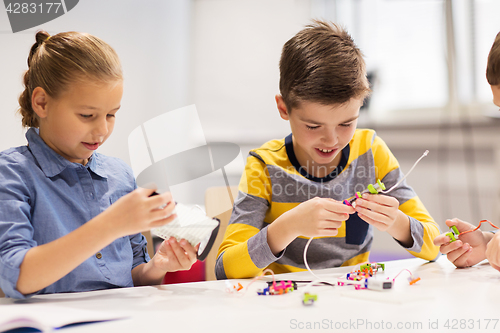 Image of happy children building robots at robotics school