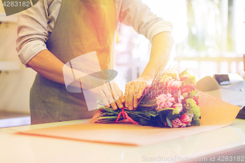 Image of florist wrapping flowers in paper at flower shop