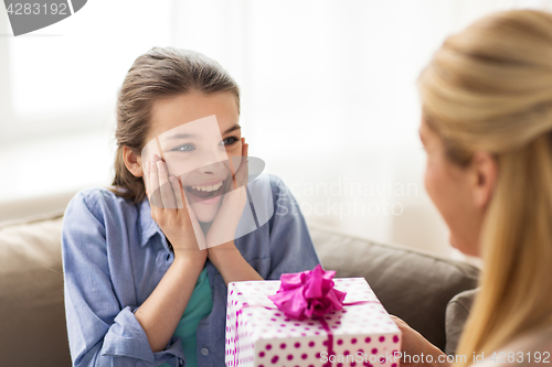 Image of mother giving birthday present to girl at home