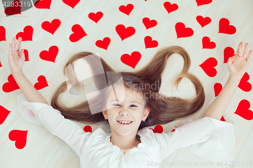 Image of One little girl lying on the floor.