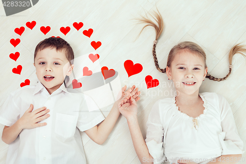 Image of little boy and girl lying on the floor.