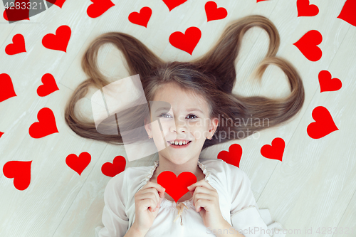 Image of One little girl lying on the floor.