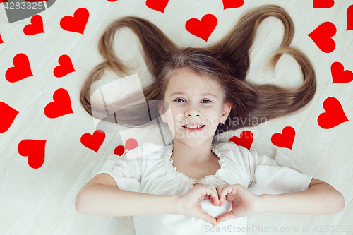 Image of One little girl lying on the floor.