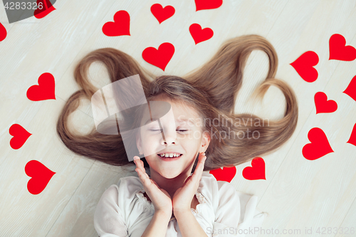 Image of One little girl lying on the floor.