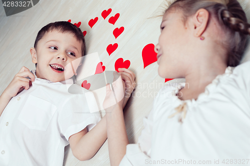 Image of little boy and girl lying on the floor.