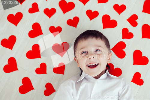 Image of One little boy lying on the floor.