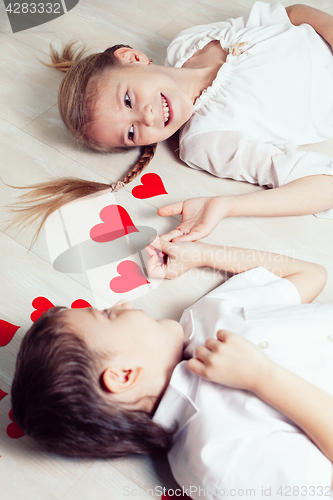 Image of little boy and girl lying on the floor.