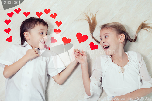 Image of little boy and girl lying on the floor.