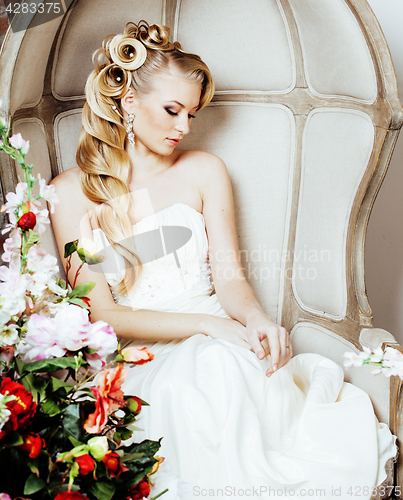 Image of beauty young blond woman bride alone in luxury vintage interior with a lot of flowers 