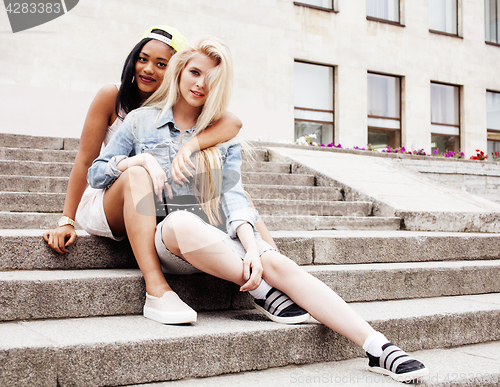 Image of Two teenage girls infront of university building smiling, having fun traveling europe, lifestyle people concept 