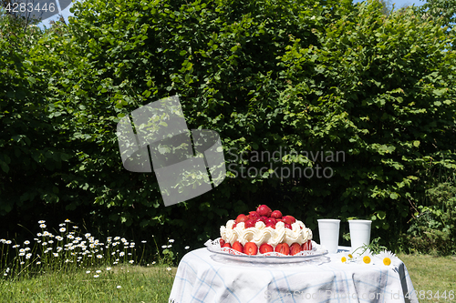 Image of Strawberry cake on a table in the garden