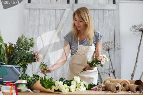 Image of Young girl florist makes bouquet