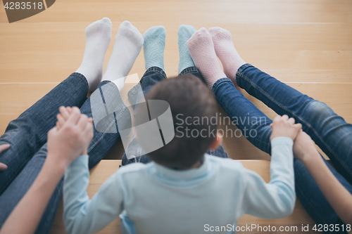 Image of happy children which are sitting on the stairs in the house.