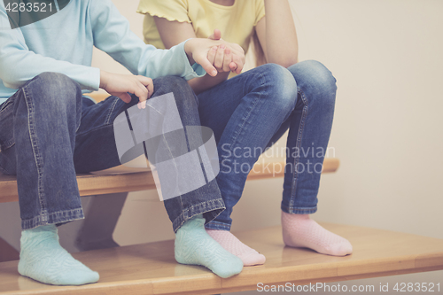 Image of happy children which are sitting on the stairs in the house.