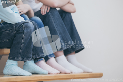 Image of happy children which are sitting on the stairs in the house.