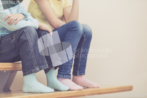 Image of happy children which are sitting on the stairs in the house.