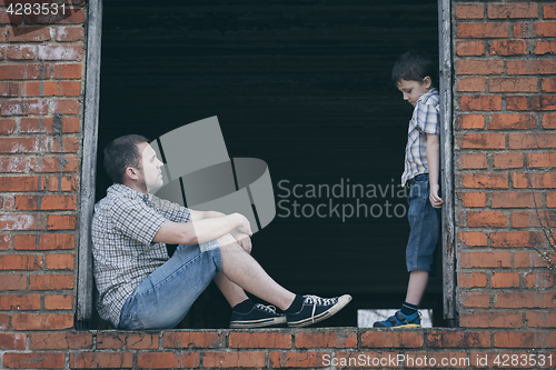 Image of Portrait of sad little boy and father.