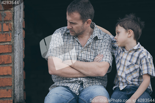 Image of Portrait of sad little boy and father.