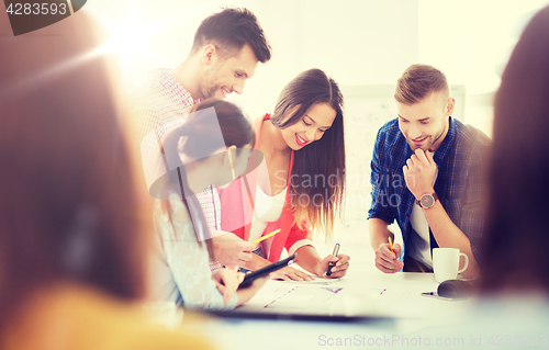 Image of happy creative team or students working at office