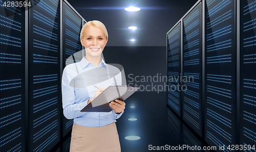 Image of businessman with clipboard over server room