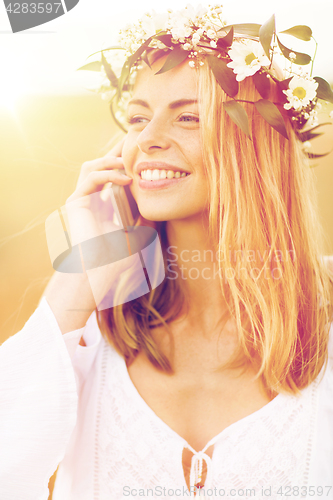 Image of happy young woman calling on smartphone at country