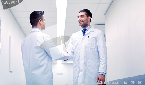 Image of smiling doctors at hospital doing handshake