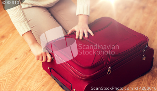 Image of close up of woman packing travel bag for vacation