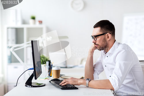 Image of businessman typing on computer keyboard at office