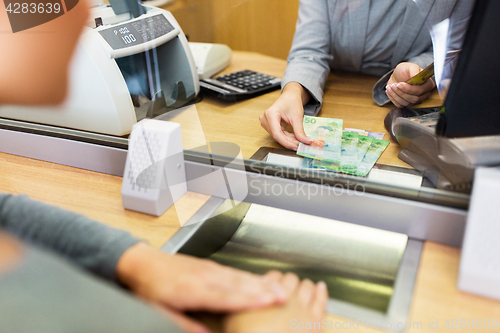 Image of clerk counting cash money at bank office